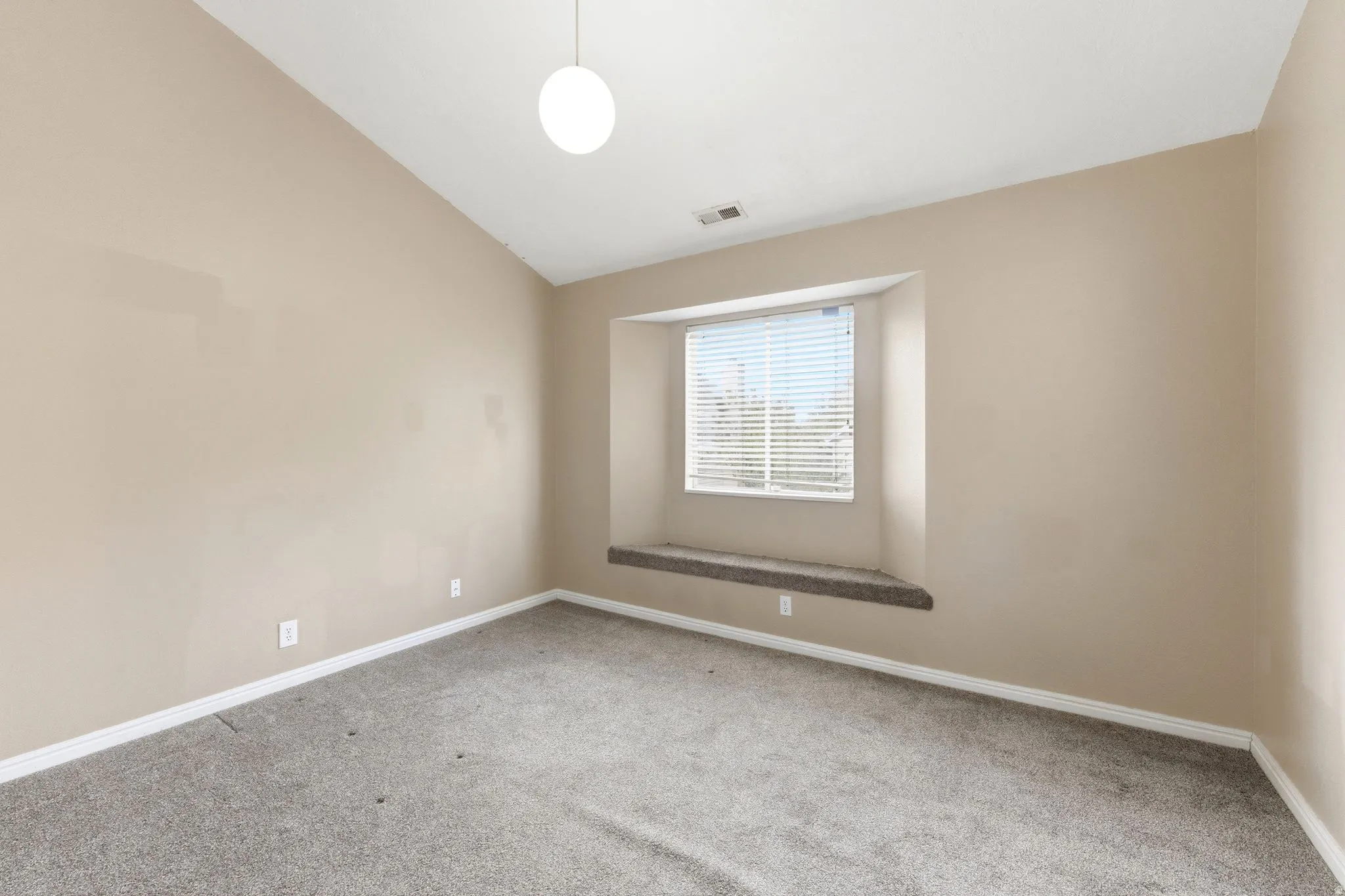 Empty room featuring lofted ceiling and light carpet