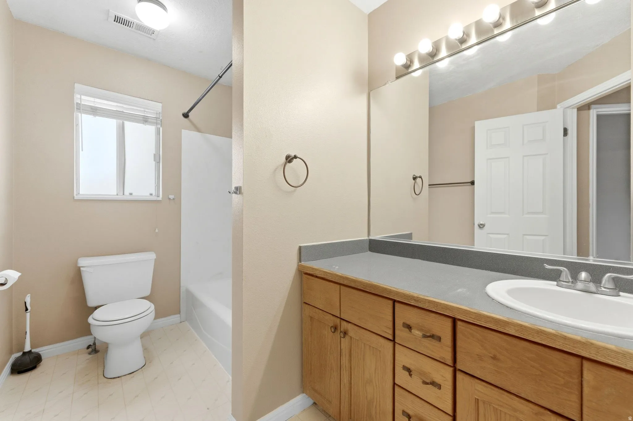 Full bath featuring vanity, shower / washtub combination, and light flooring