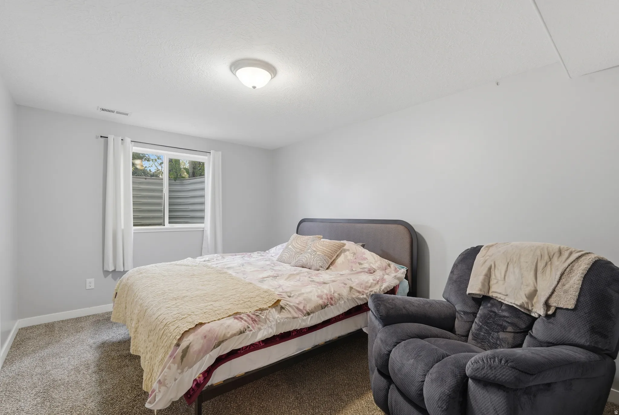 Bedroom with carpet and a textured ceiling