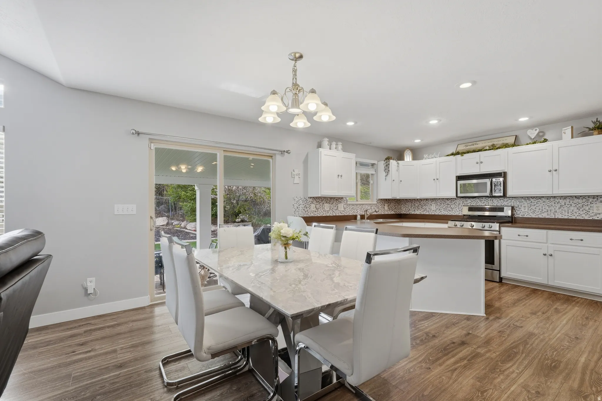 Dining space with light wood-style floors and a chandelier