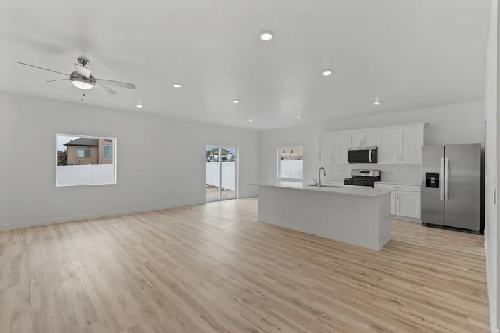 Open concept living area featuring light wood-finish flooring, recessed lighting, and a ceiling fan