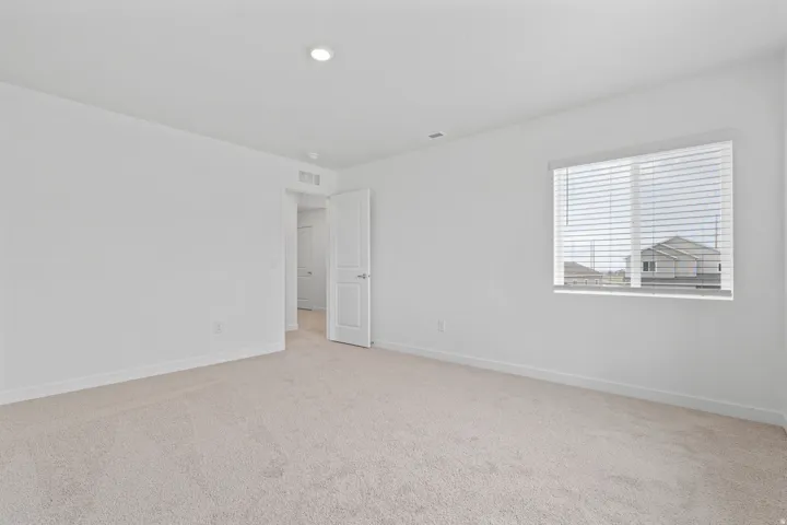 Neutral-toned wall-to-wall carpeting complements the white walls and trim