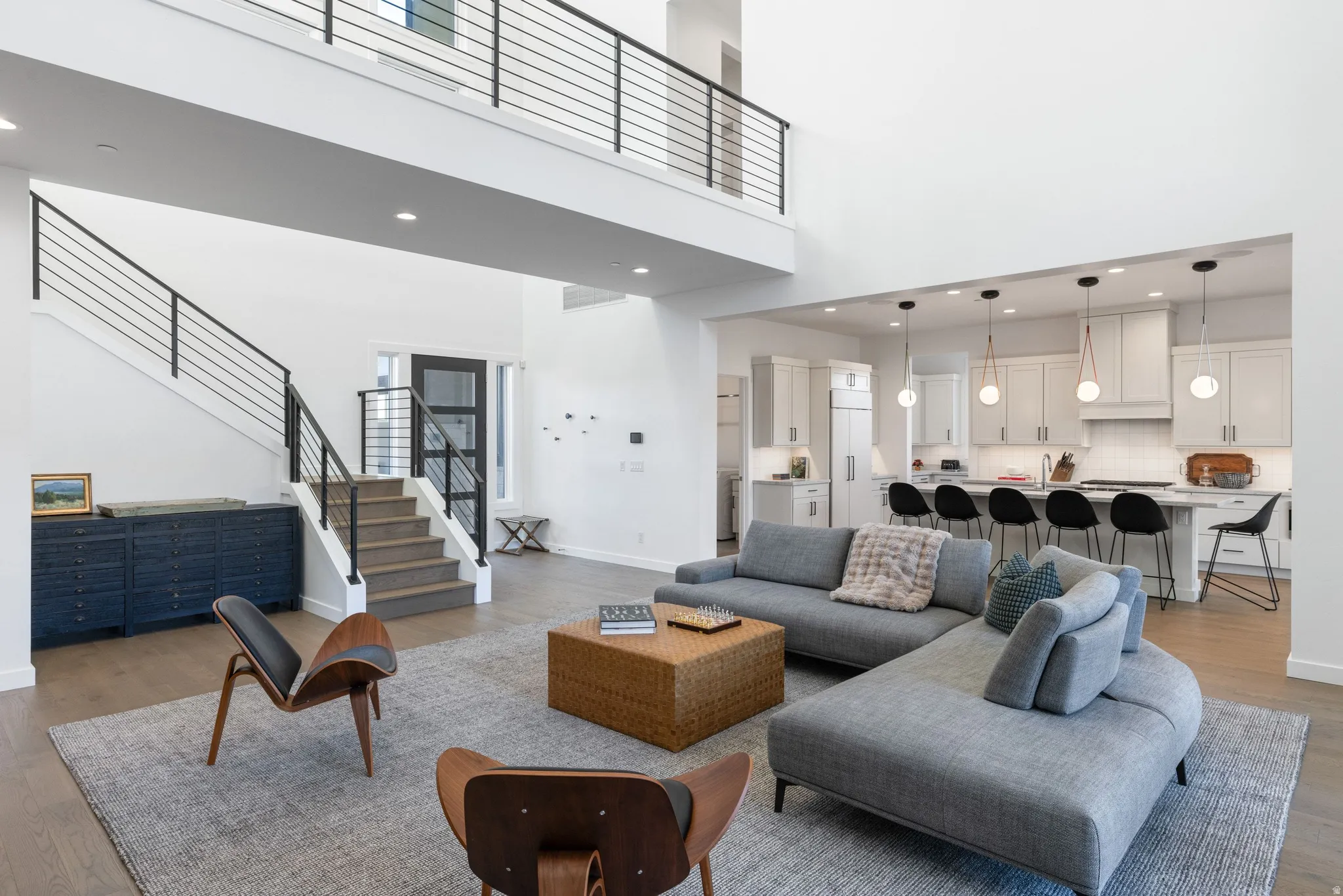 Living area featuring light wood-style floors, a high ceiling, and recessed lighting