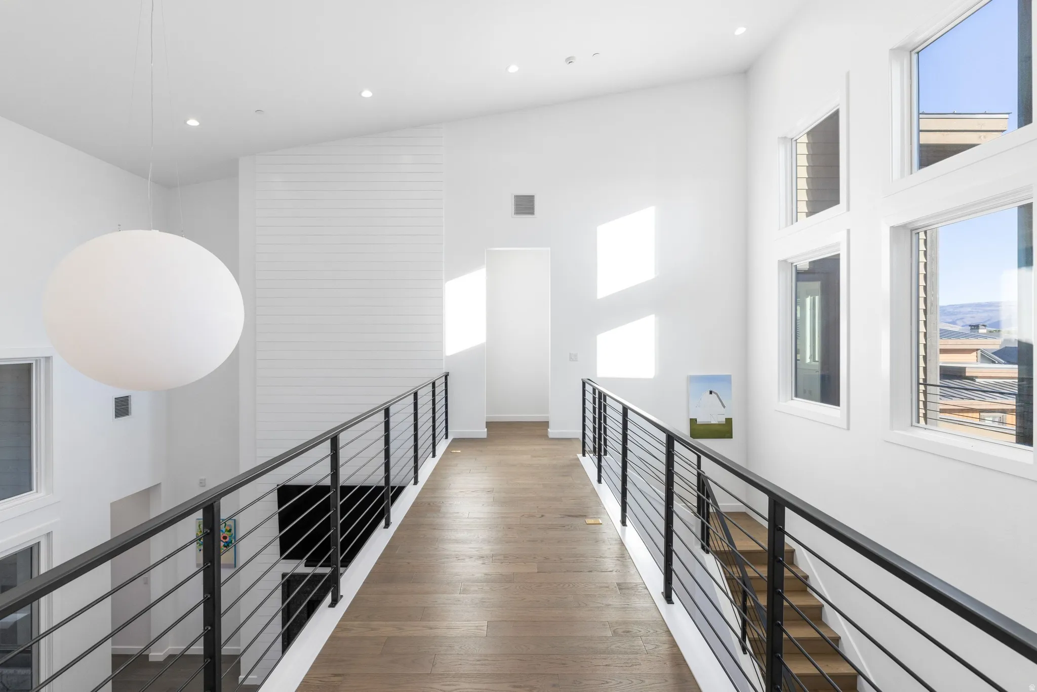 Hallway featuring dark wood finished floors, an upstairs landing, recessed lighting, and vaulted ceiling