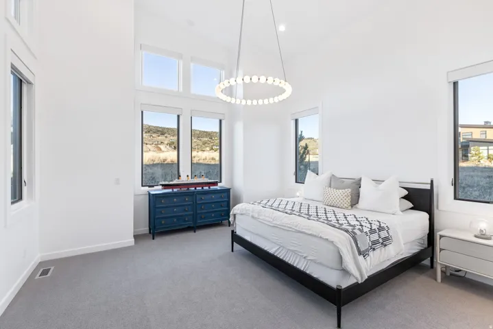 Carpeted bedroom featuring a high ceiling and recessed lighting