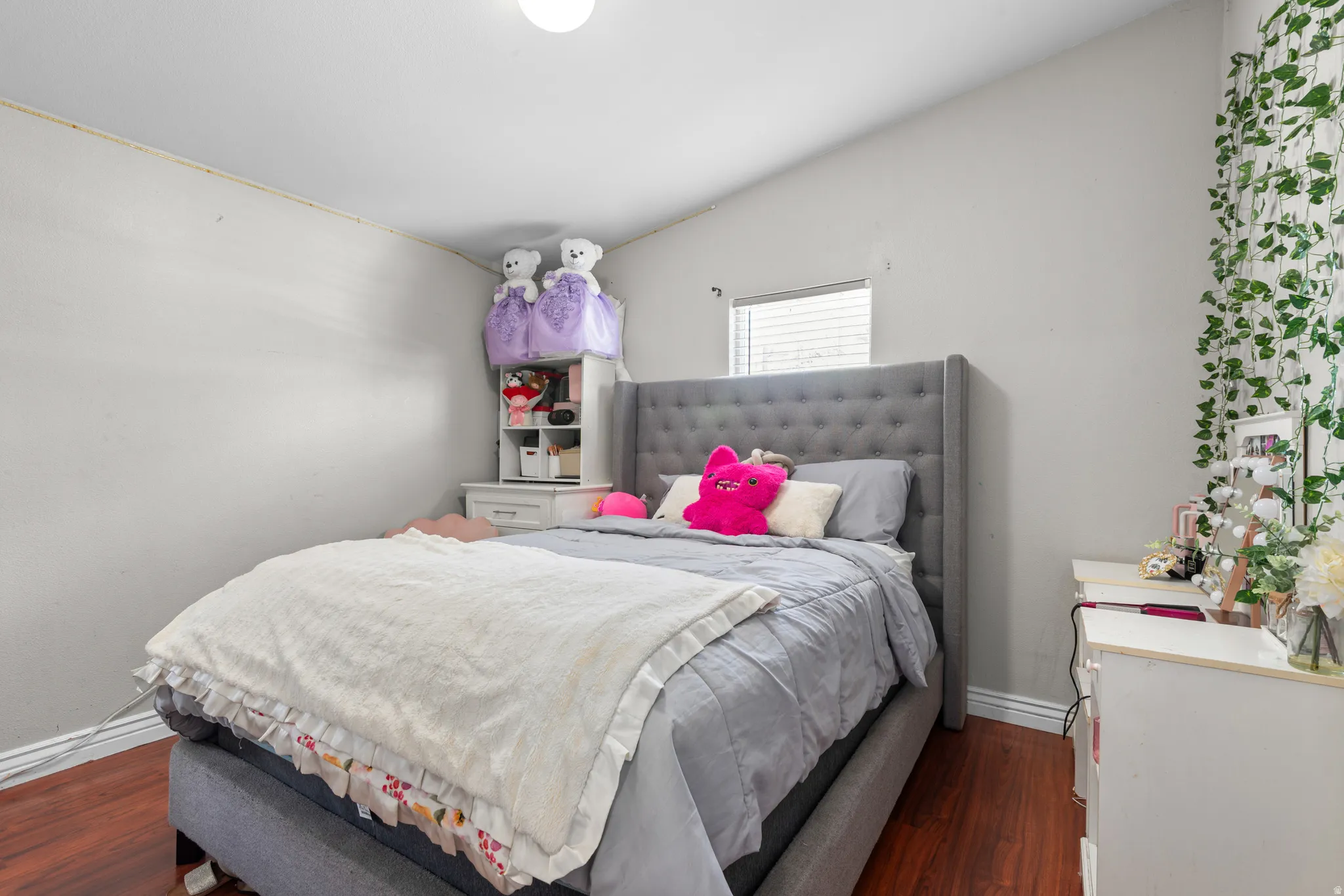 Bedroom featuring dark wood-style floors and baseboards
