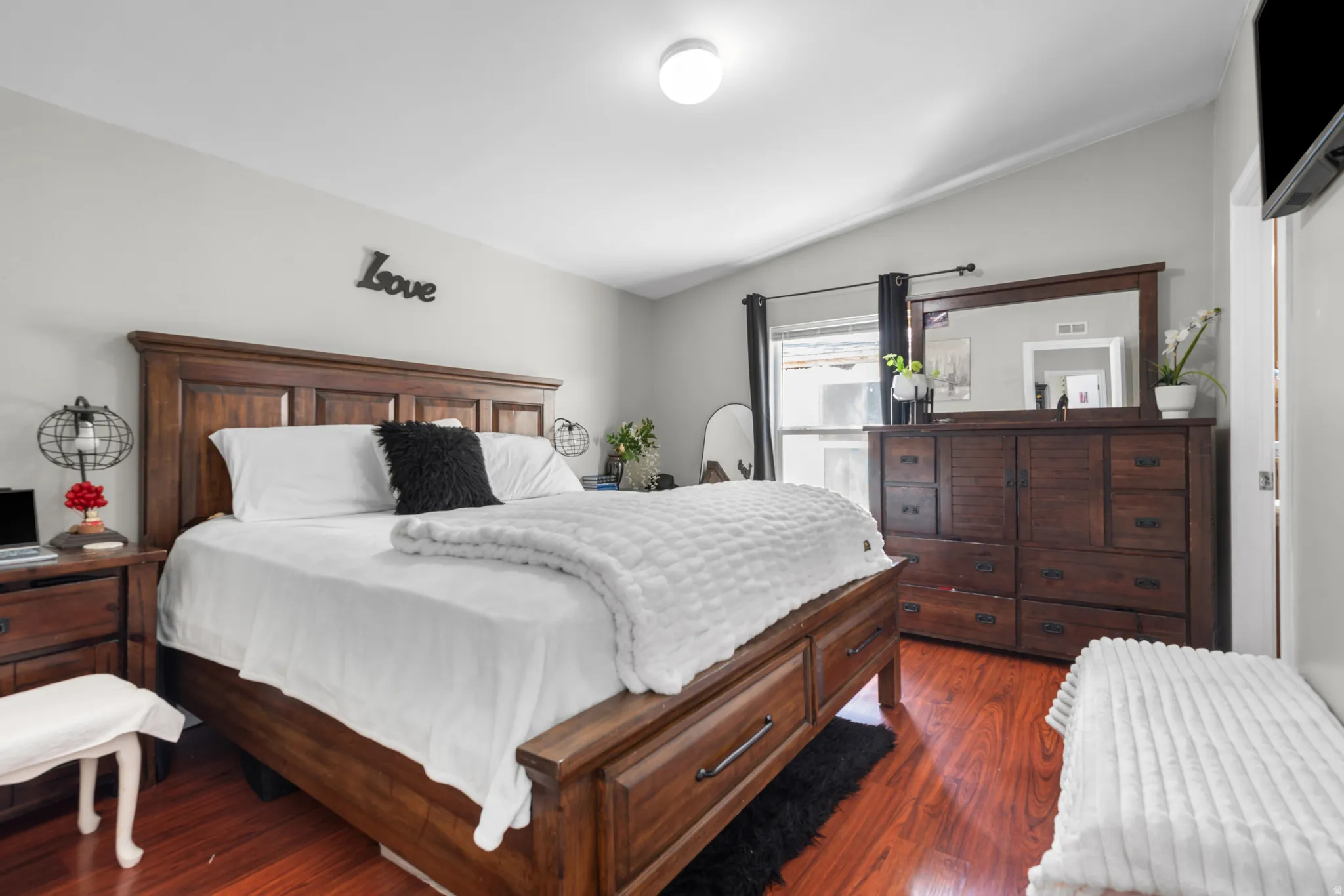 Bedroom featuring vaulted ceiling and dark wood-type flooring