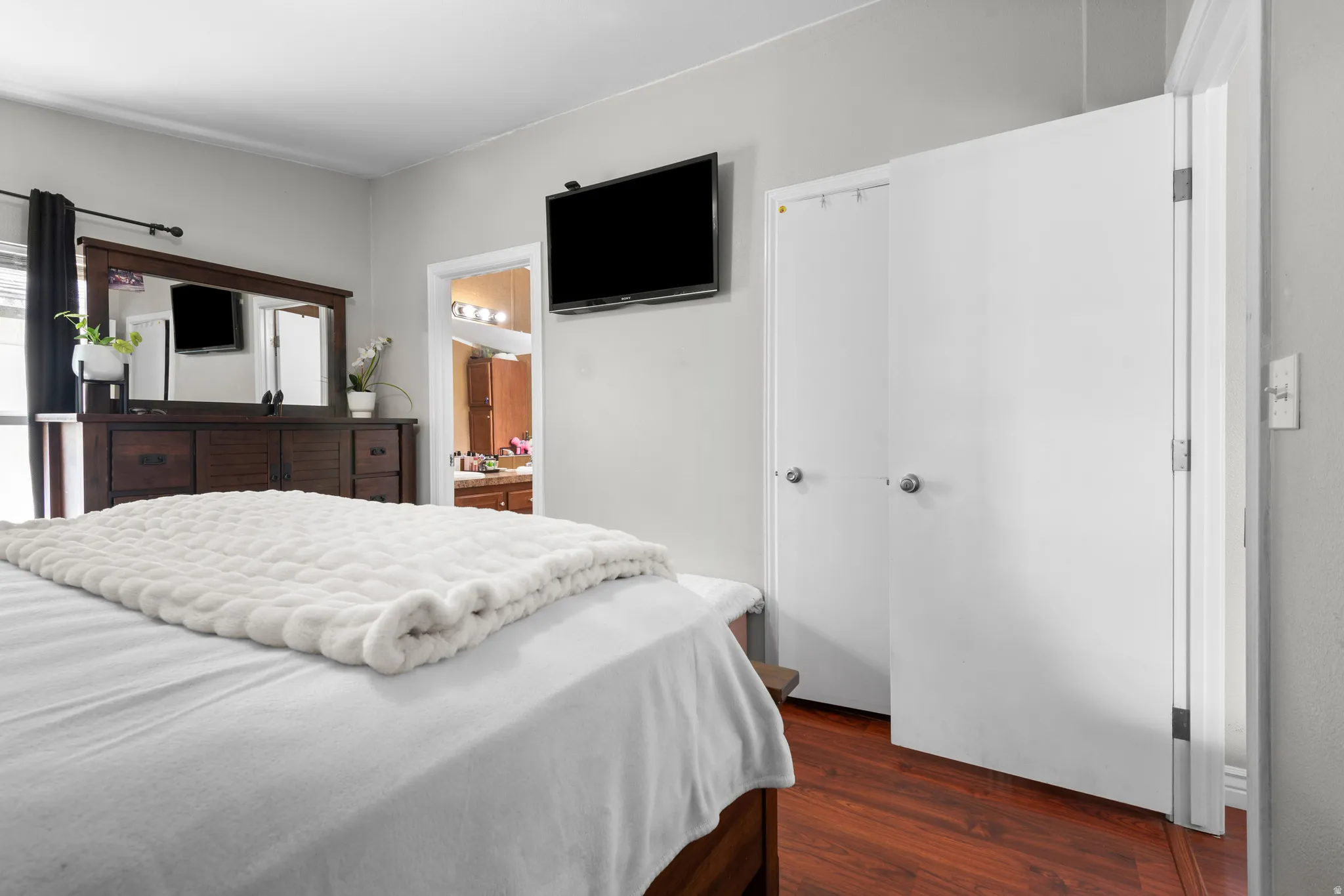 Bedroom with dark wood-style floors and ensuite bathroom