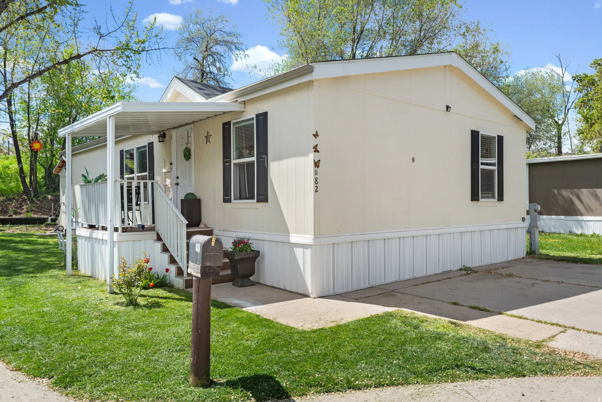 Manufactured / mobile home with covered porch and a front yard