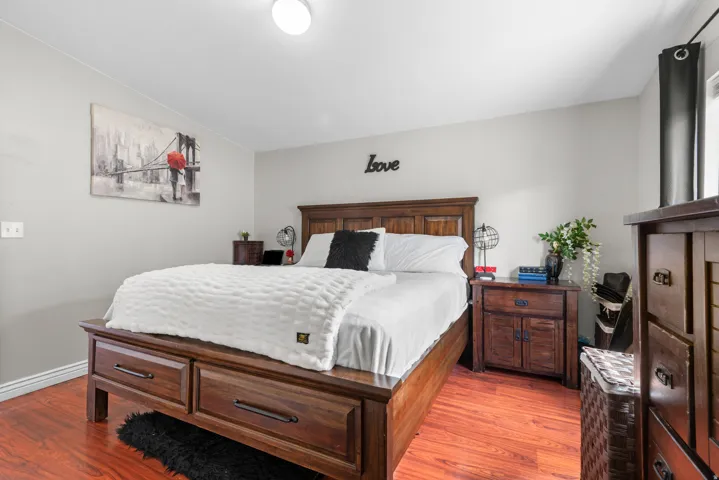 Bedroom with light wood finished floors and lofted ceiling