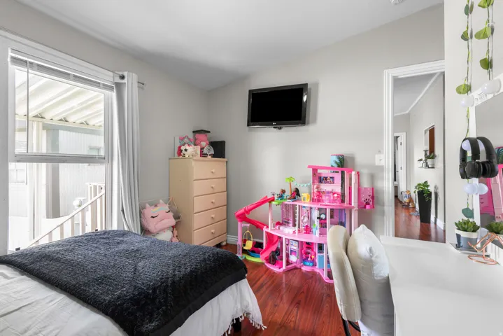 Bedroom featuring dark wood-style flooring and lofted ceiling