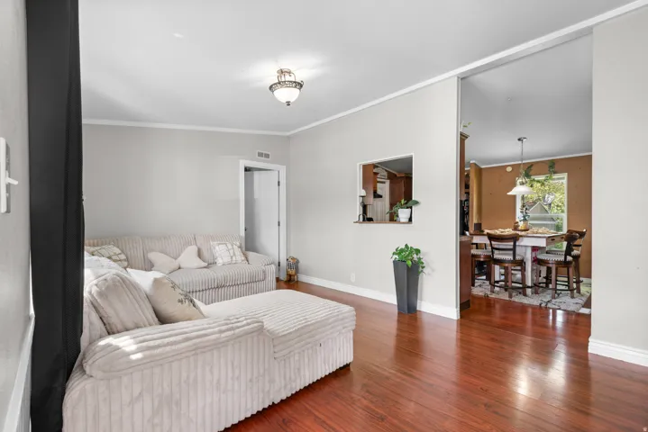 Living room with dark wood-style flooring and crown molding