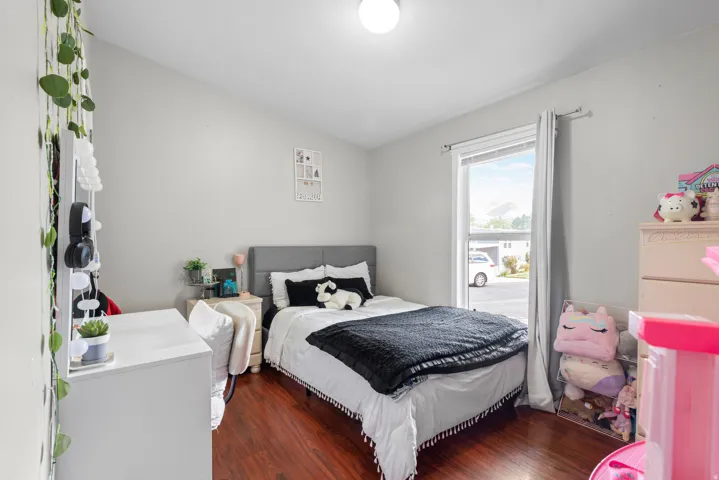 Bedroom with dark wood-style flooring and vaulted ceiling