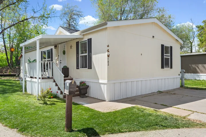 Manufactured / mobile home with covered porch and a front yard