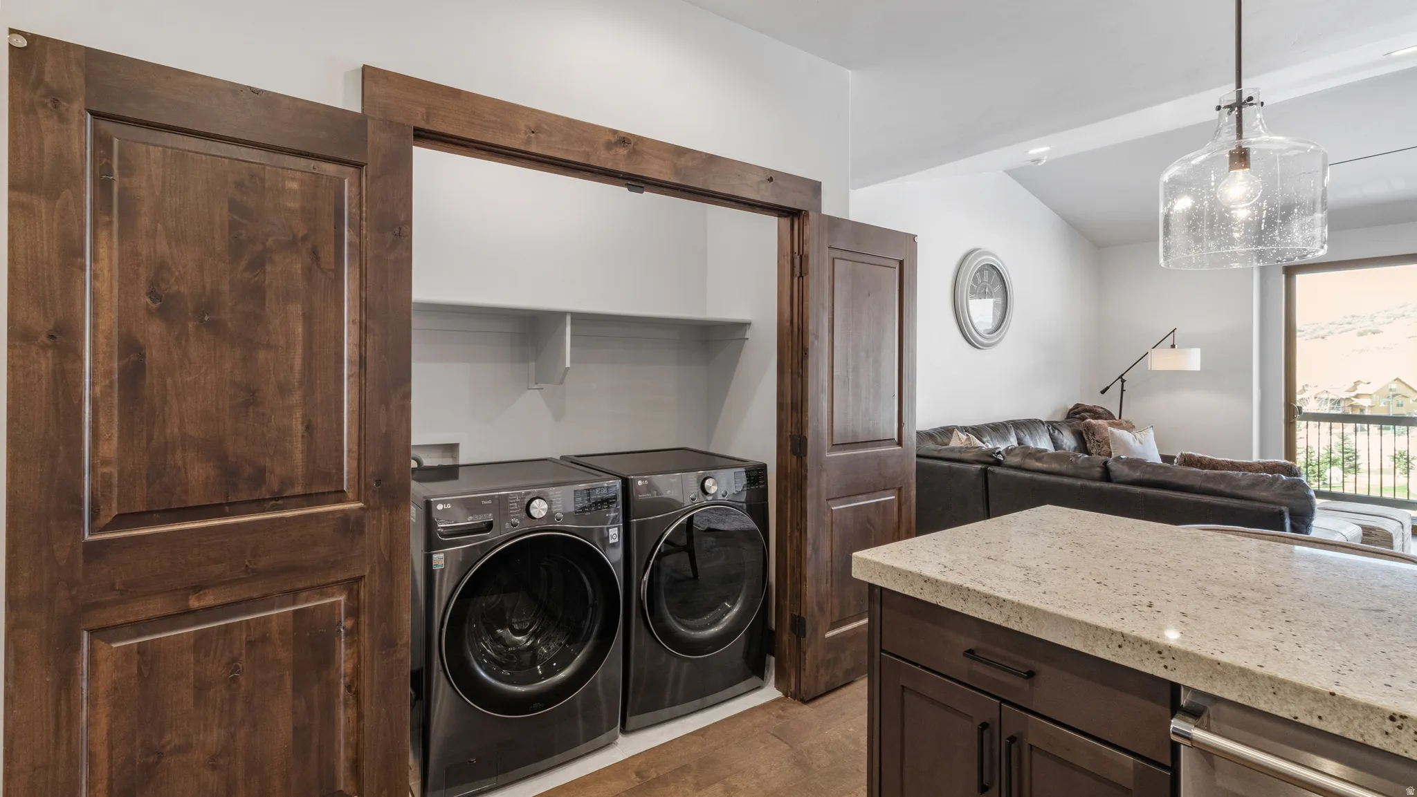 Laundry area with washer and clothes dryer, light wood-style flooring, and vaulted ceiling