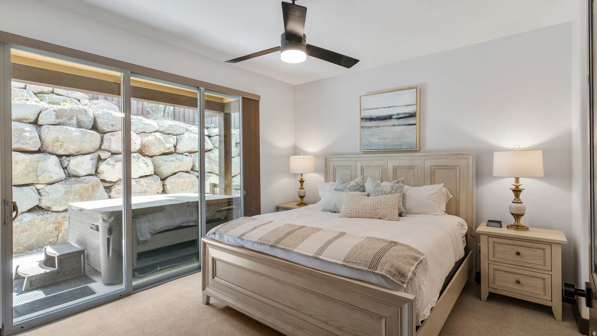 Bedroom with light carpet, a ceiling fan, and access to outside