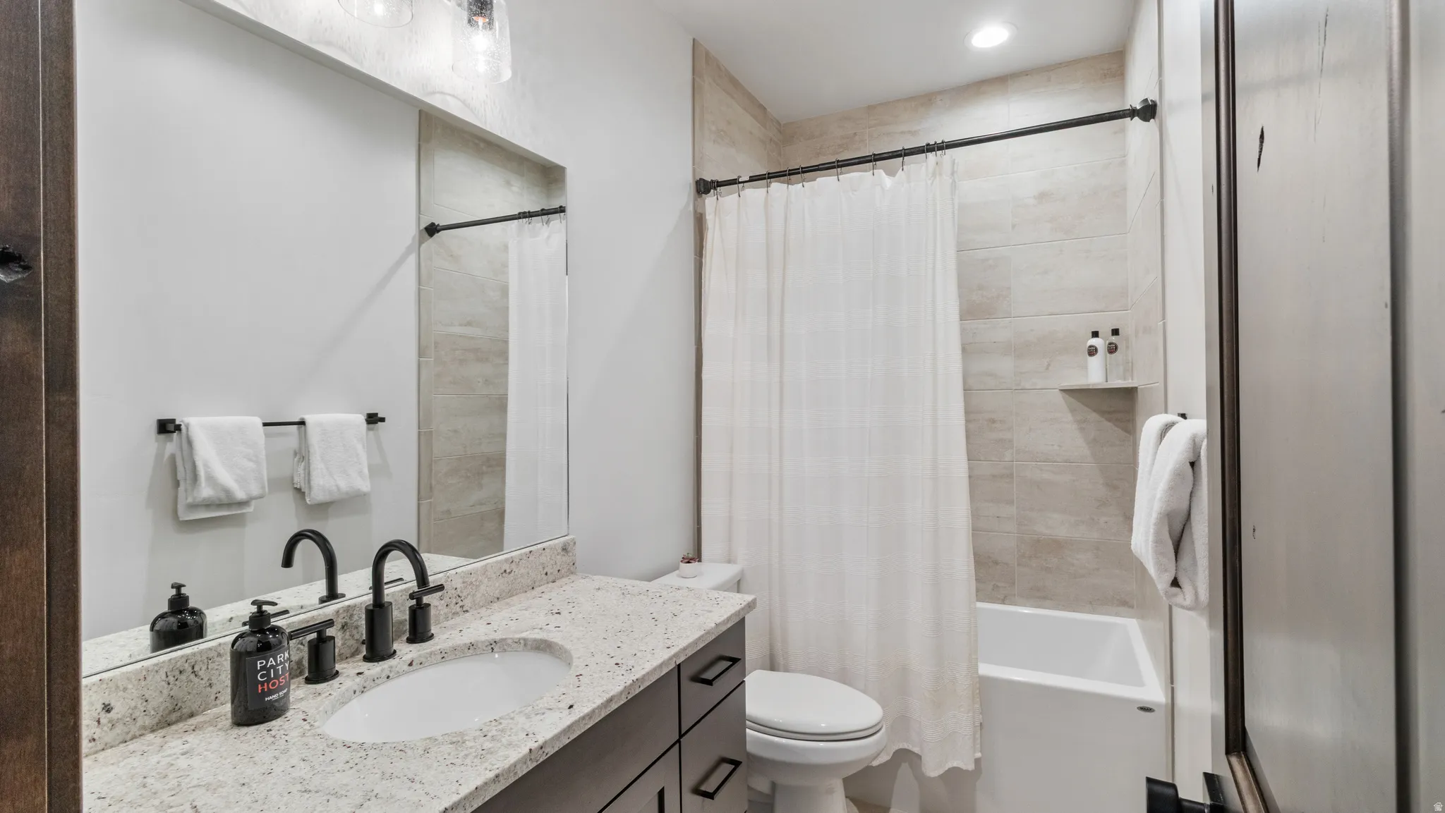 Bathroom featuring vanity and shower / bath combo with shower curtain