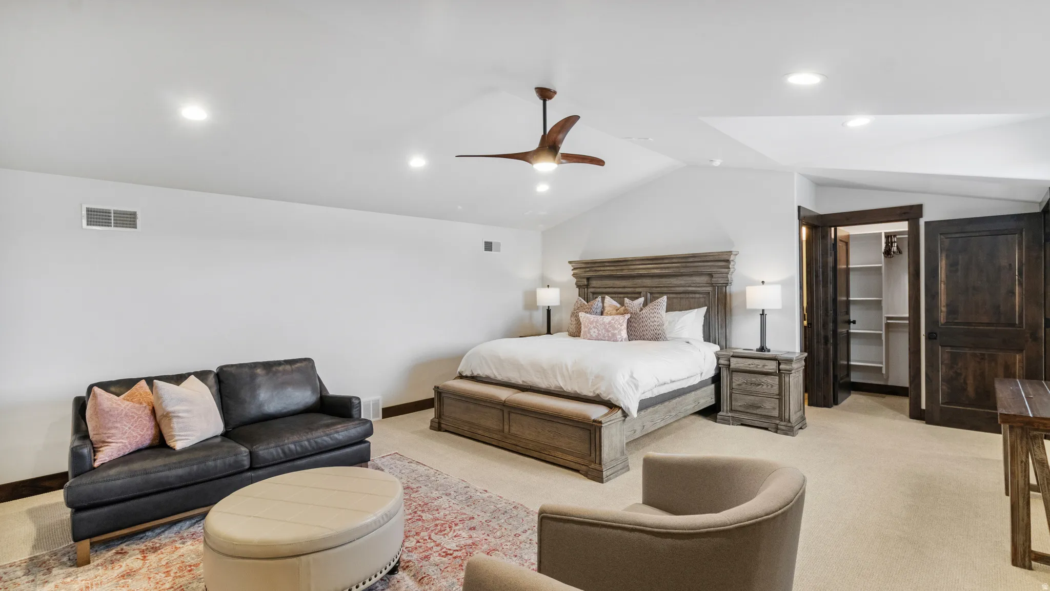 Carpeted bedroom featuring a spacious closet, vaulted ceiling, ceiling fan, and recessed lighting