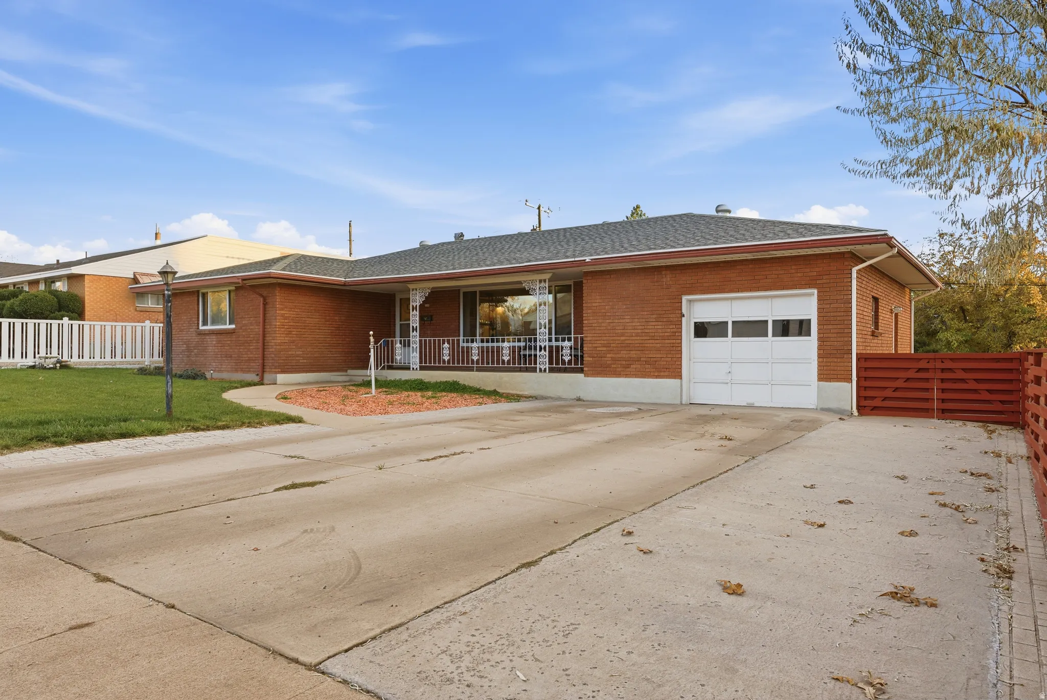 Ranch-style house with driveway, brick siding, an attached garage, and a shingled roof