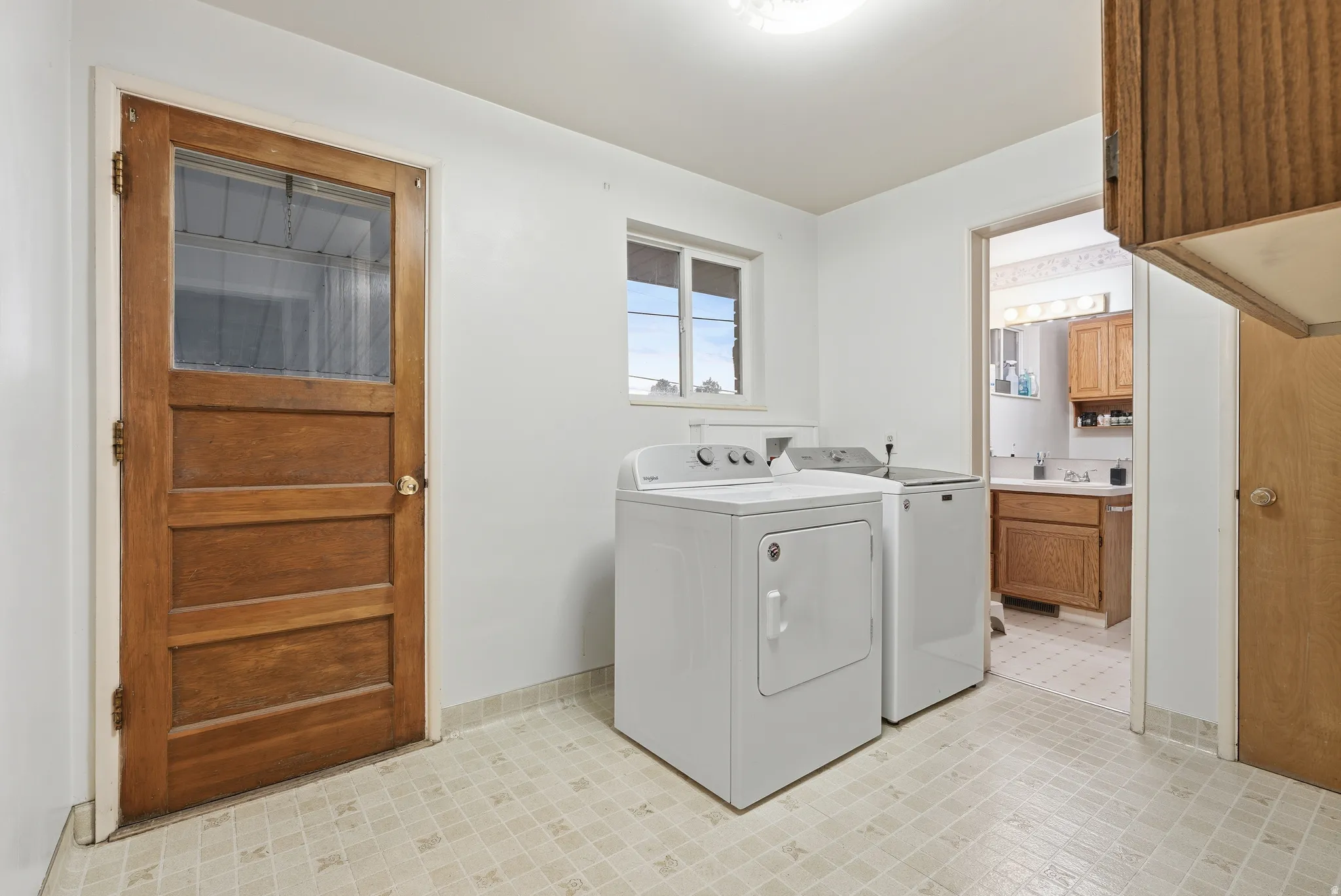 Laundry area featuring light floors and washer and dryer