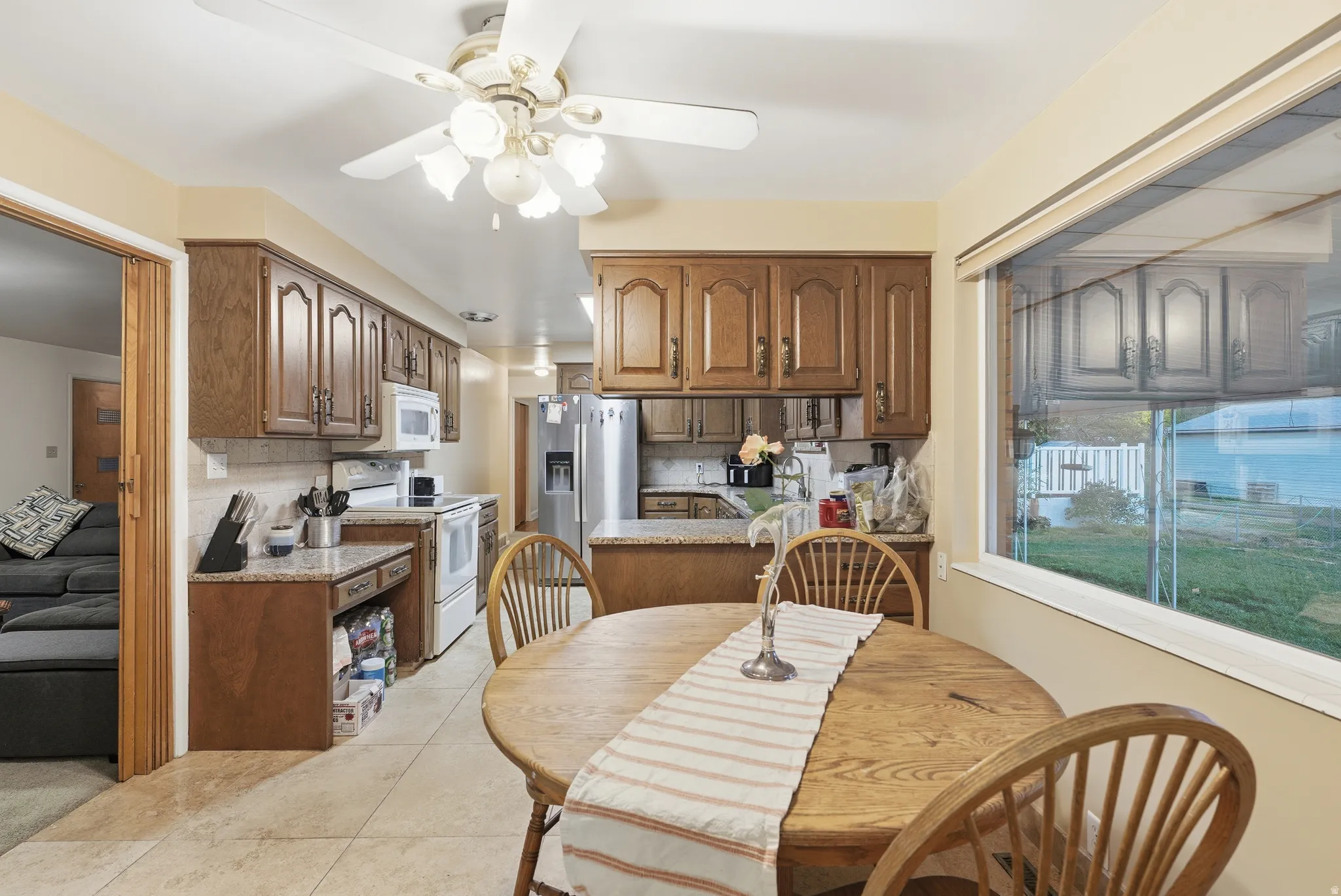 Dining space with ceiling fan and light tile patterned flooring