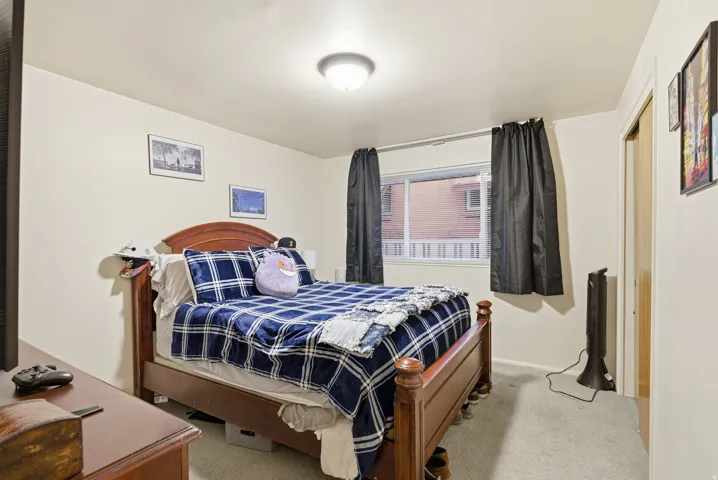 Bedroom with light colored carpet and a closet