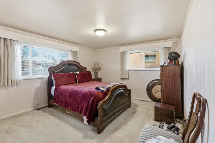 Bedroom with light colored carpet and baseboards