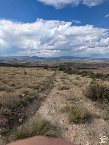 Expansive open land featuring a natural terrain with dry grasses and scattered brush