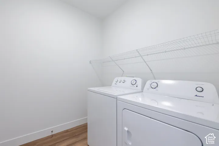 Laundry area featuring wood-finish flooring and integrated white wire shelving