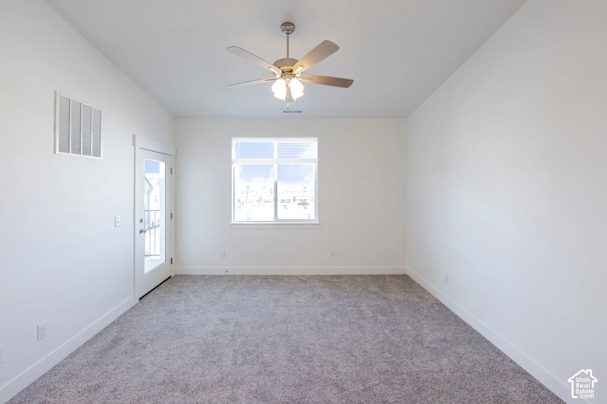 Neutral-toned carpet, ceiling fan with integrated lighting, window with a horizontal pane, and glass-paneled exterior door
