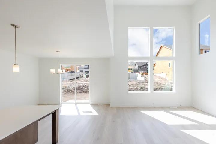 Expansive interior with high ceilings, multiple large windows, and light wood-finish flooring