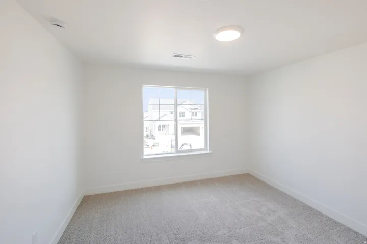 Recessed lighting, large window, neutral carpeting, and white walls