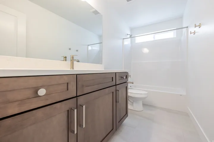 Bathroom featuring a vanity with dark wood-finish cabinetry, a light-toned countertop, and a built-in mirror