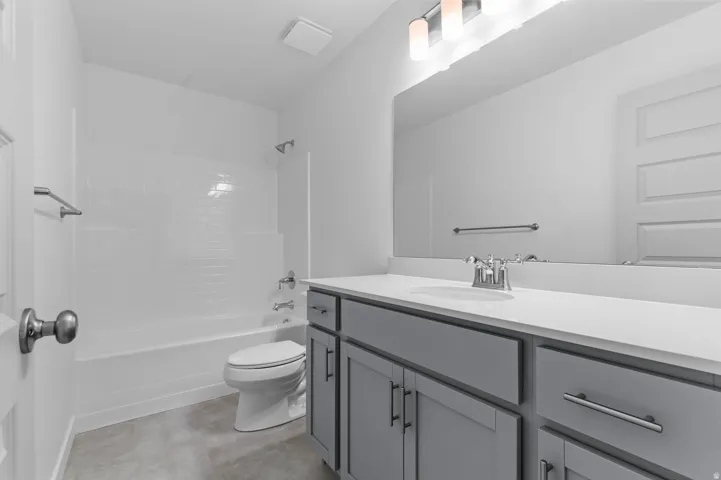 Bathroom featuring a vanity with a white countertop and gray cabinetry