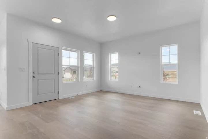 Open concept living space featuring light wood-finish flooring and recessed ceiling lighting
