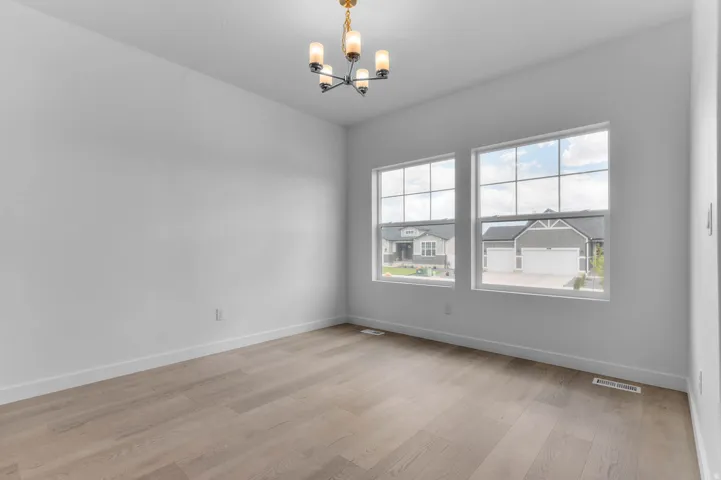 Room featuring light wood-finish flooring, white baseboards, and crisp white walls