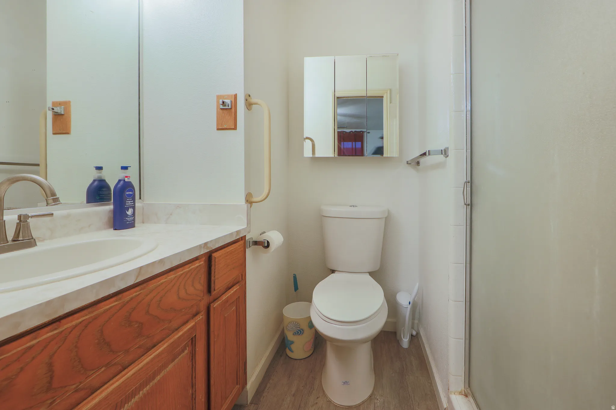 Bathroom featuring vanity, a stall shower, and dark wood-type flooring