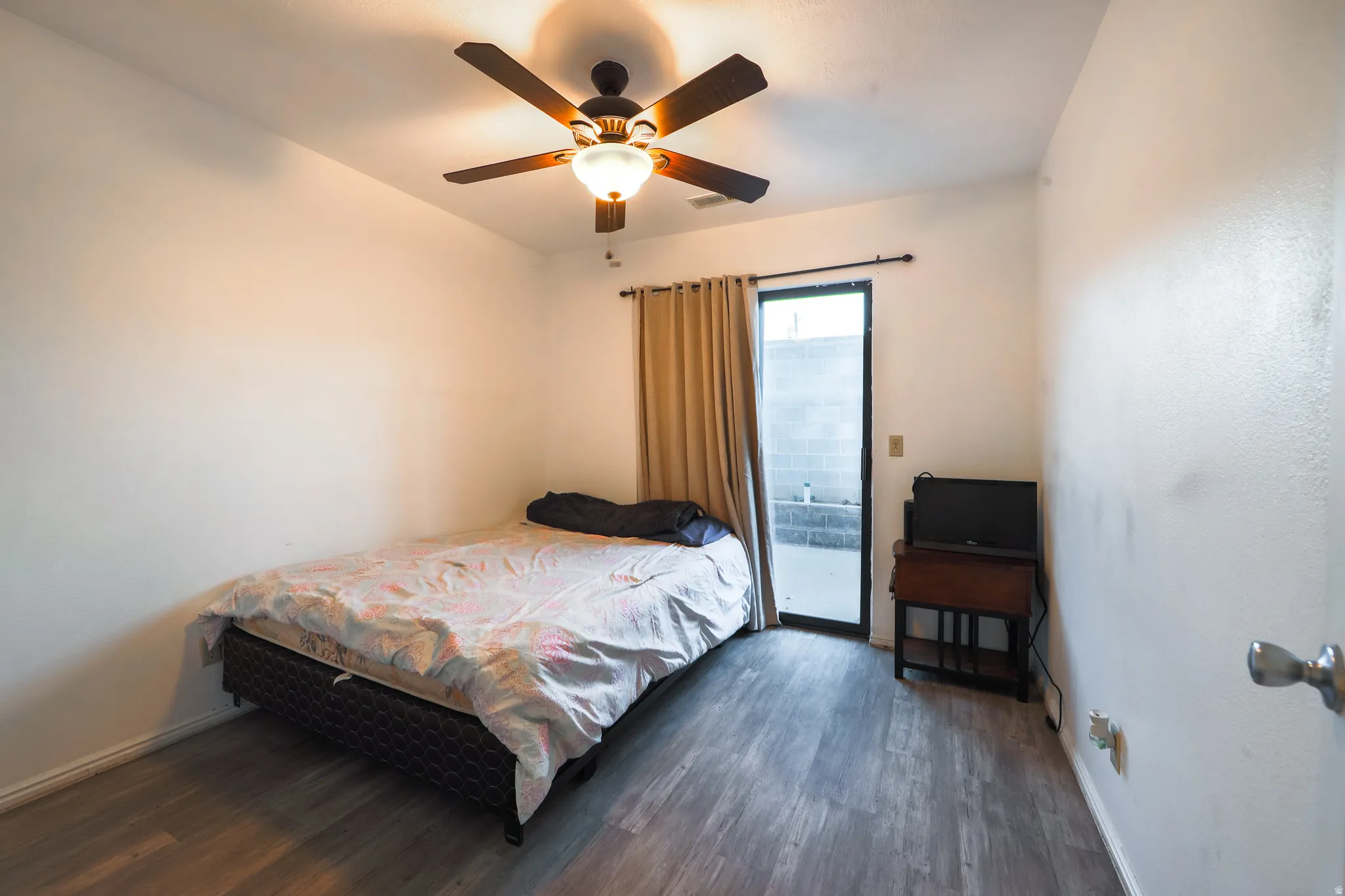 Bedroom with access to exterior, dark wood-type flooring, and ceiling fan