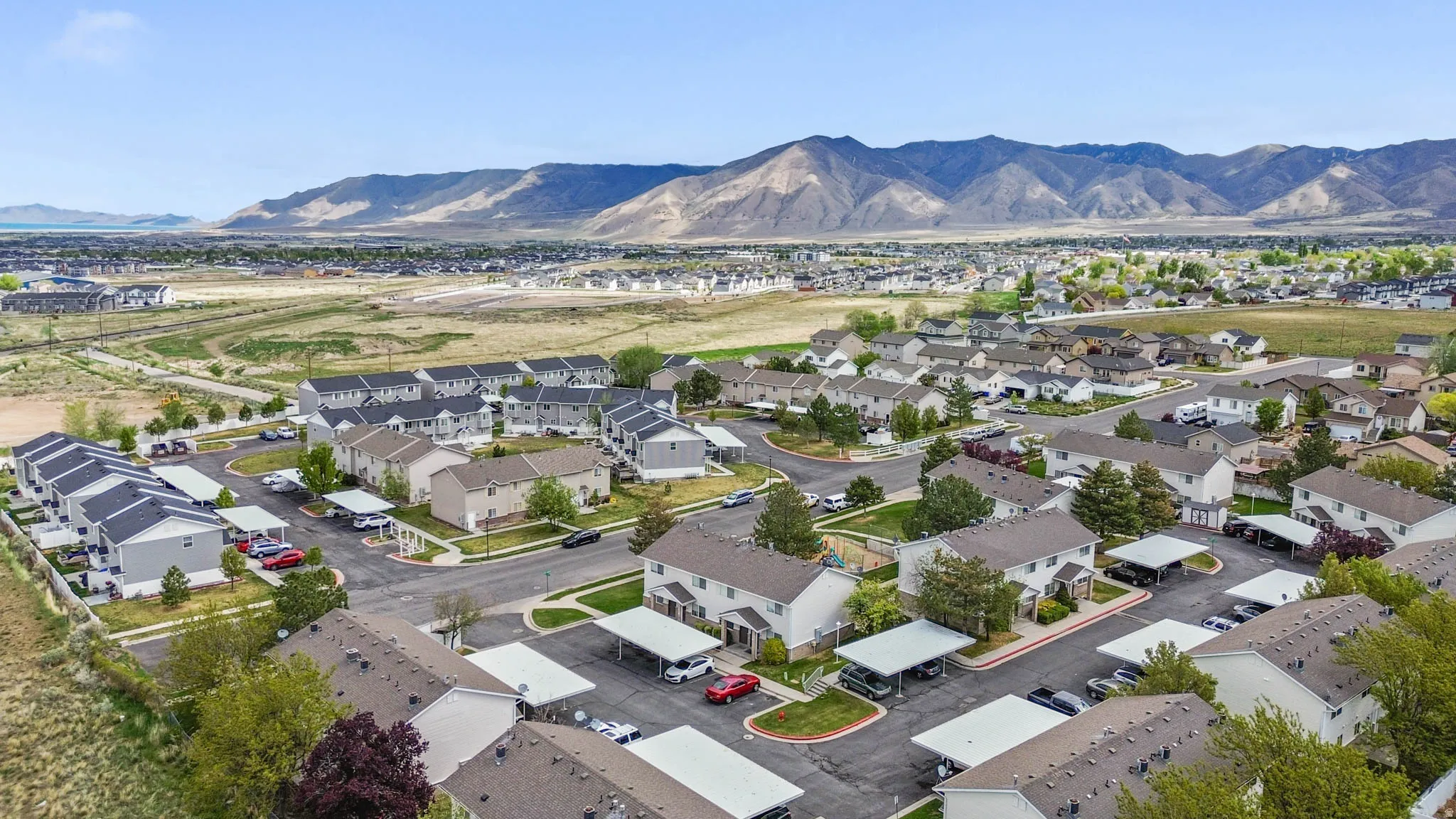 Aerial view of property and surrounding area featuring a mountain backdrop