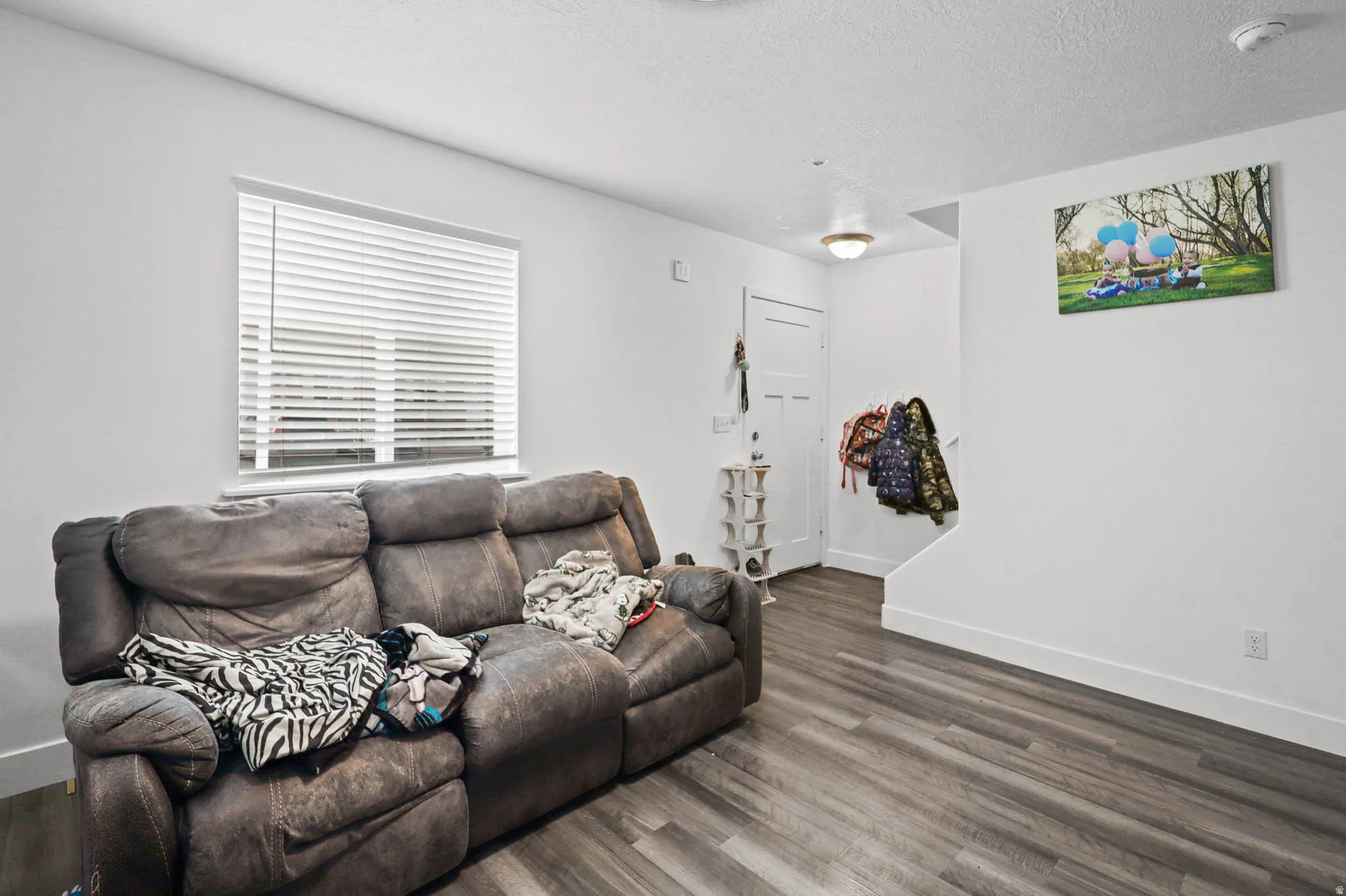 Living area featuring dark wood-style flooring and a textured ceiling