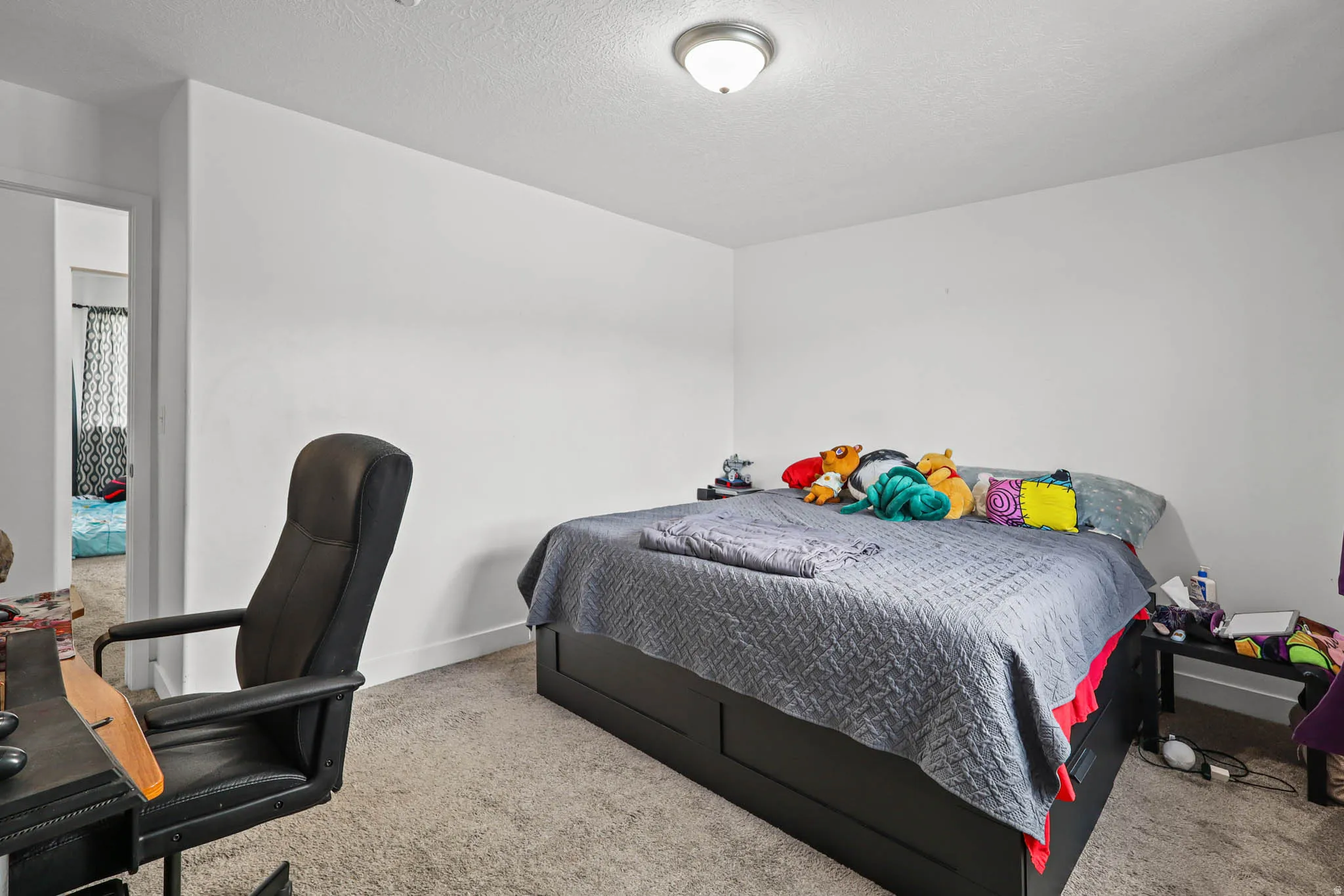 Bedroom featuring light colored carpet and a textured ceiling