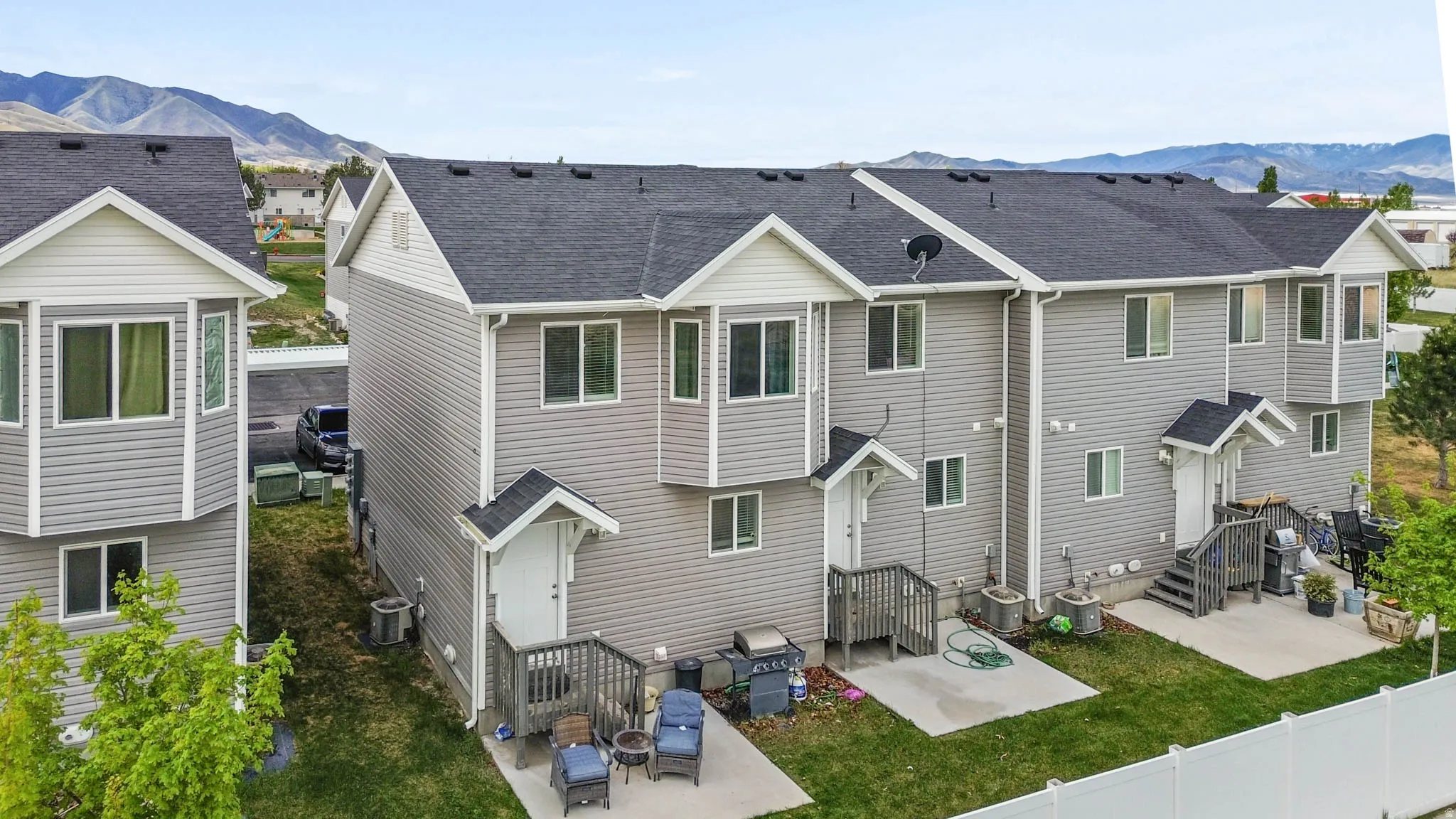 Rear view of house with a mountain view, a patio area, and roof with shingles