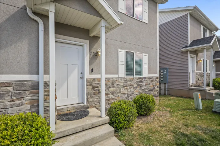 Property entrance featuring stone siding and stucco siding