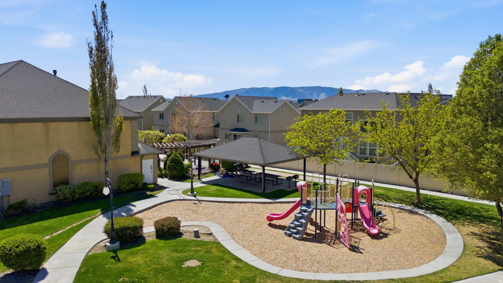 Communal playground featuring a patio area, a mountain view, and a residential view