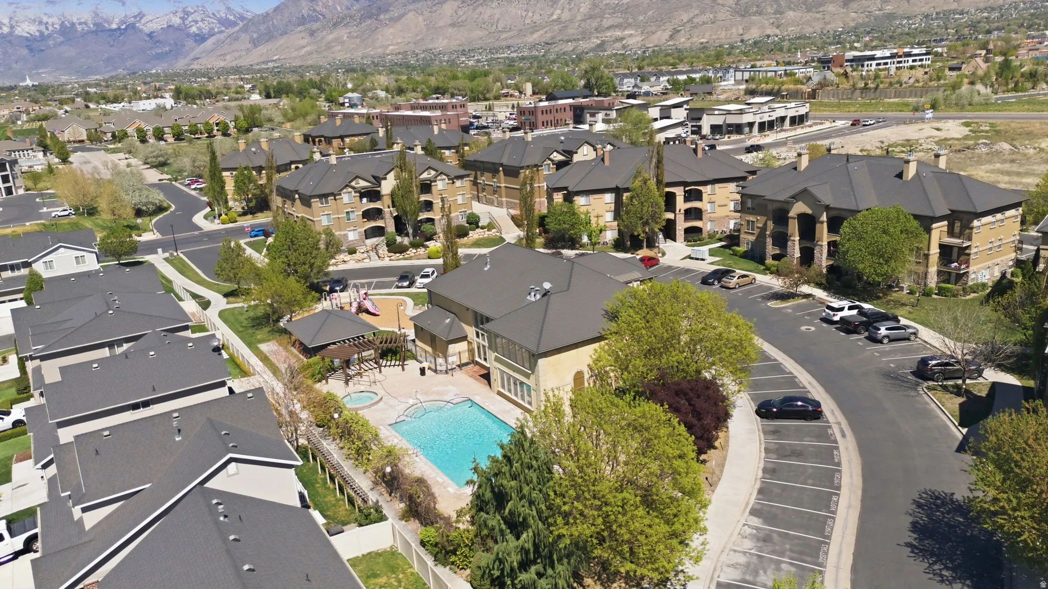 Aerial view of property and surrounding area with a mountainous background and nearby suburban area