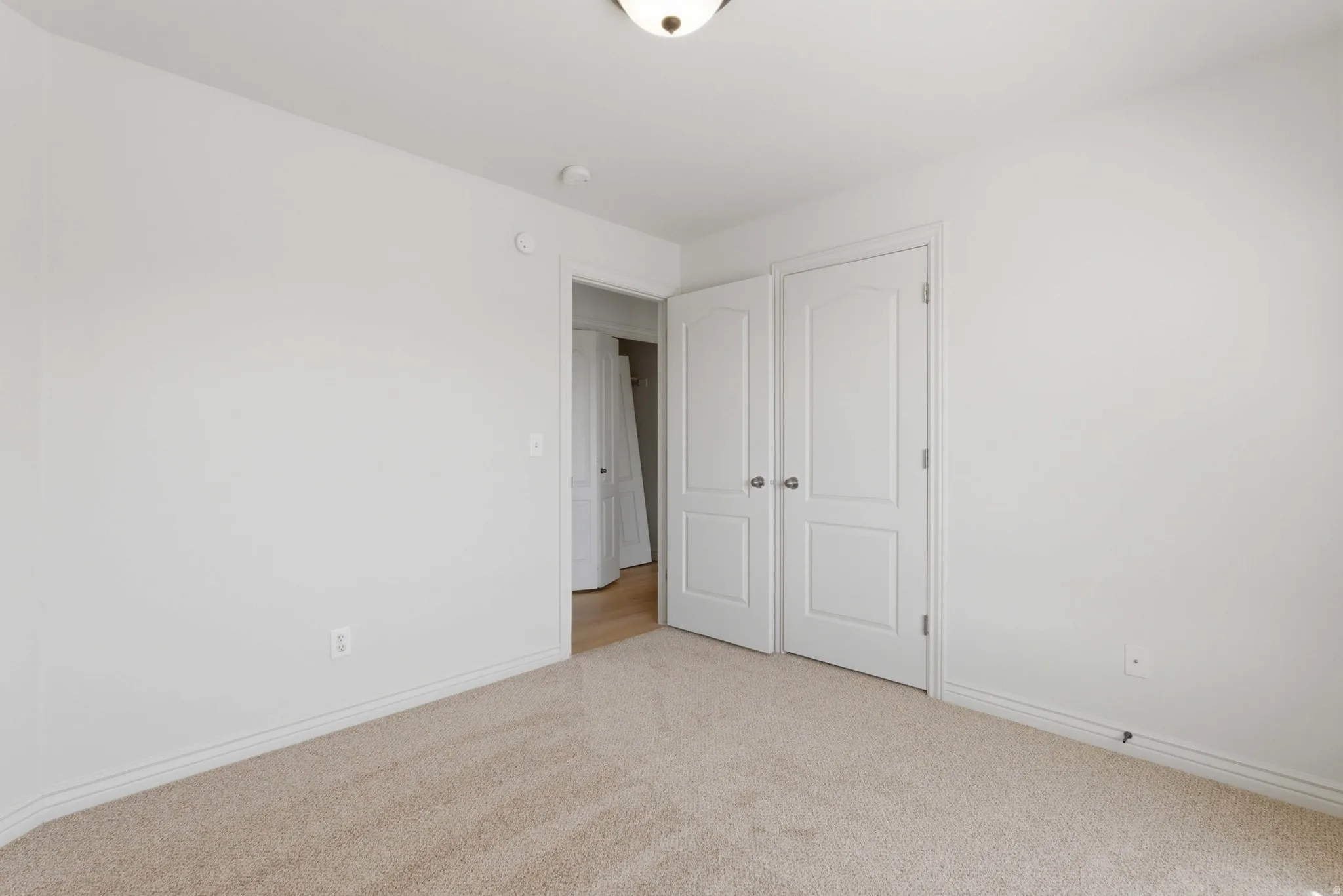 Unfurnished bedroom with light colored carpet and a closet
