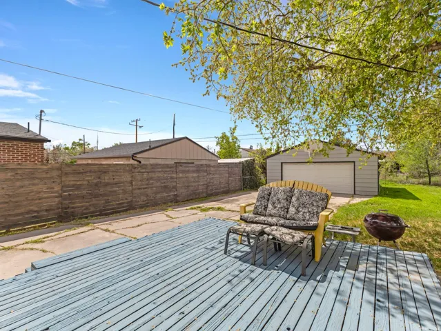 Wooden deck a detached garage with an beautiful privacy fence.