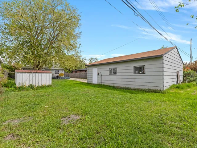Large yard and side view of garage.