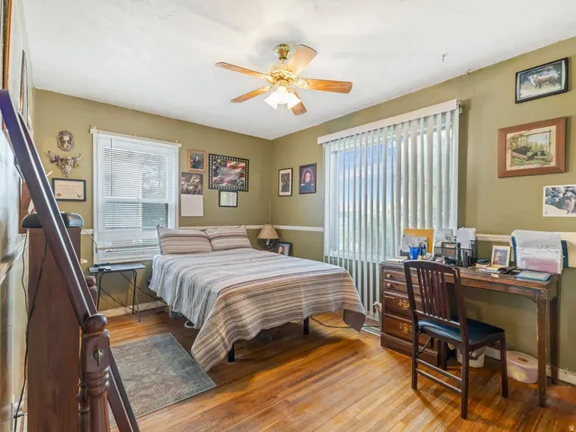 Bedroom featuring hardwood / wood-style flooring, a ceiling fan, and multiple windows