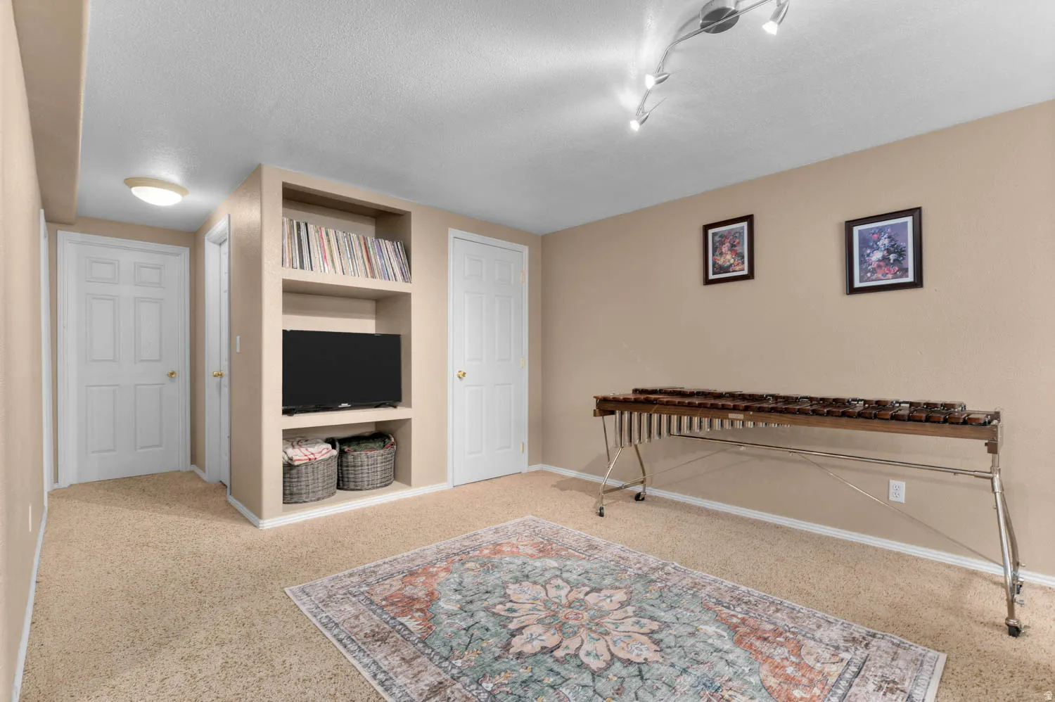 Sitting room featuring built in features, light carpet, and a textured ceiling